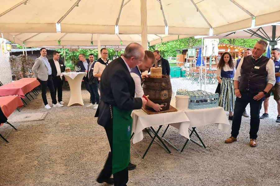 Celebrating long-standing and potential customers at a dinner party in a typical Bavarian restaurant, with a traditional meal and ceremonial tapping of the beer barrel.